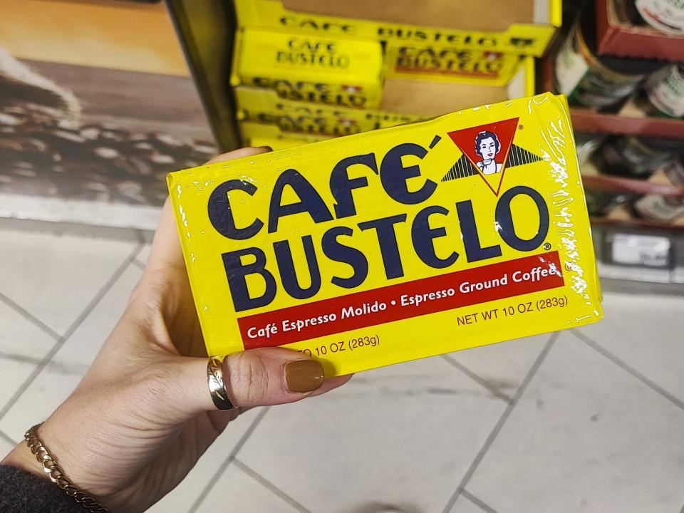 A hand holding a box of Café Bustelo coffee.