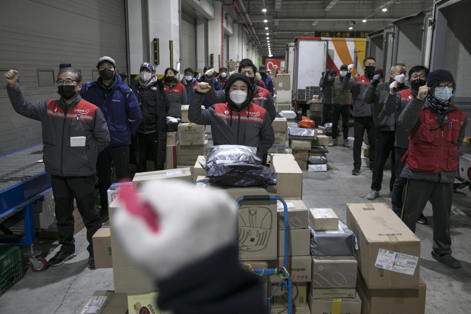 Los repartidores levantan los puños mientras cantan una canción sindical en un almacén en Seúl, Corea del Sur, el 30 de noviembre de 2020. (Woohae Cho/The New York Times).