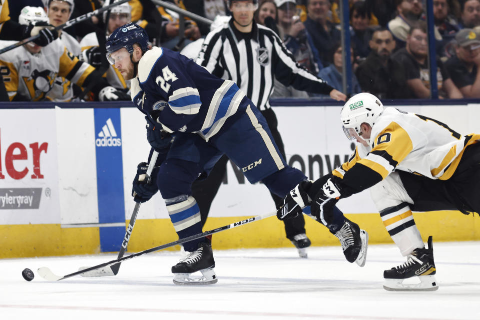 Columbus Blue Jackets forward Mathieu Olivier (24) controls the puck in front of Pittsburgh Penguins forward Drew O'Connor during the second period of an NHL hockey game in Columbus, Ohio, Saturday, March 30, 2024. (AP Photo/Paul Vernon)