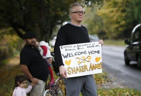 Well wisher Andrew Jackson holds a placard after the aircraft carrying Shaker Aamer, the last British resident to be held at the U.S. prison camp in the Guantanamo Bay navy station in Cuba, landed at Biggin Hill airport near London, October 30, 2015. REUTERS/Peter Nicholls