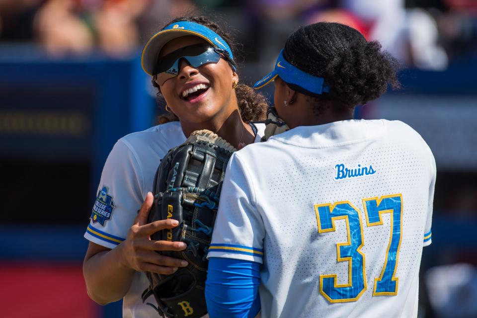 UCLA Bruins first baseman Kinsley Washington (37) and center fielder Maya Brady (7) talk and laugh during the sixth inning of the NCAA Women's College World Series game against the Florida Gators at USA Softball Hall of Fame Stadium. UCLA won 8-0.