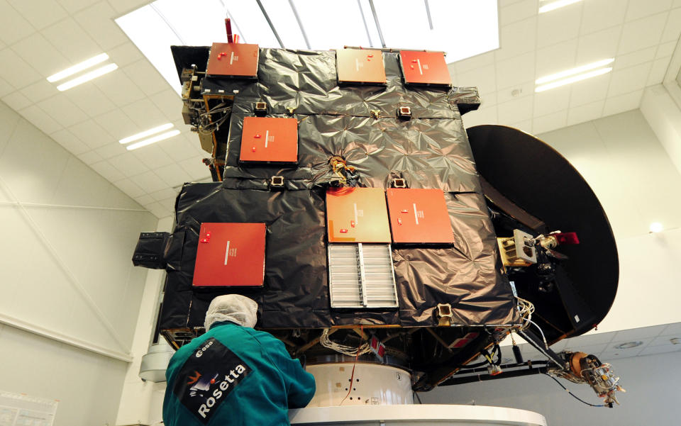 A scientist of European space agency ESA stands at an airworthy copy of space probe 'Rosetta' in the ESA control center in Darmstadt, Germany, Monday, Jan. 20, 2014. Scientists at the European Space Agency are expecting their comet-chasing probe Rosetta to wake from almost three years of hibernation at 11 a.m. Monday Jan. 20, 2014 (1000 GMT; 5 a.m. EST) and phone home to say all is well. The scientists are facing an agonizing wait of several hours until the first signal reaches Earth. (AP Photo/dpa, Daniel Reinhardt)