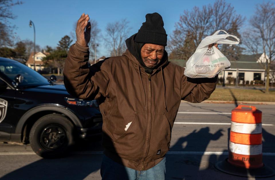 Albert Carter cries and prays after a Secret Santa elf gives him a $100 bill in Lincoln Park on Thursday, Dec. 14, 2023.