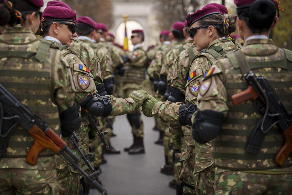 Members of a Romanian military unit hold hands before the National Day parade in Bucharest, Romania, Friday, Dec. 1, 2023. Tens of thousands of people turned out in Romania's capital on Friday to watch a military parade that included troops from NATO allies to mark the country's National Day. (AP Photo/Vadim Ghirda)