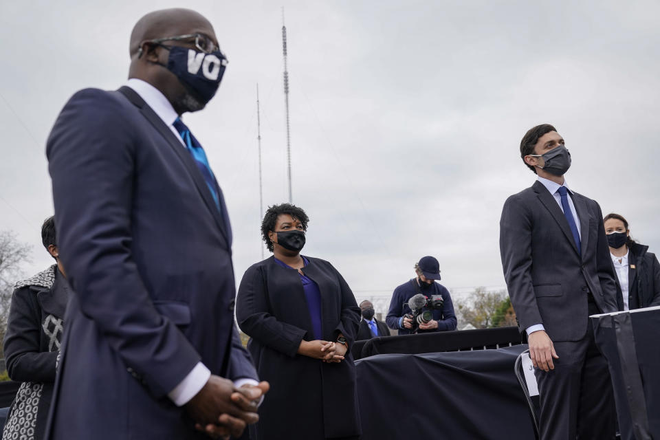 Democratic Senate candidate Raphael Warnock, Stacey Abrams and U.S. Democratic Senate candidate Jon Ossoff listen as U.S. President-elect Joe Biden speaks during a campaign rally at Pullman Yard. (Photo by Drew Angerer/Getty Images)