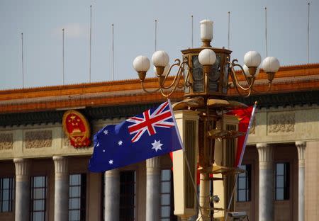 An Australian national flag flutters next to a Chinese national flag in front of the Great Hall of the People at the Tiananmen Square in Beijing April 9, 2013. REUTERS/Petar Kujundzic