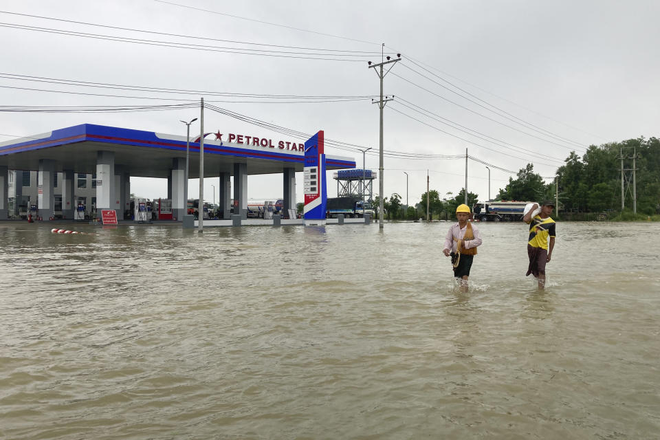 Local residents wade through a flooded road in Bago, about 80 kilometers (50 miles) northeast of Yangon, Myanmar, Monday, Oct. 9, 2023. Flooding triggered by heavy monsoon rains in Myanmar’s southern areas has displaced more than 10,000 people and disrupted traffic on the rail lines that connect the country’s biggest cities, officials and state-run media said Monday.(AP Photo/Thein Zaw)