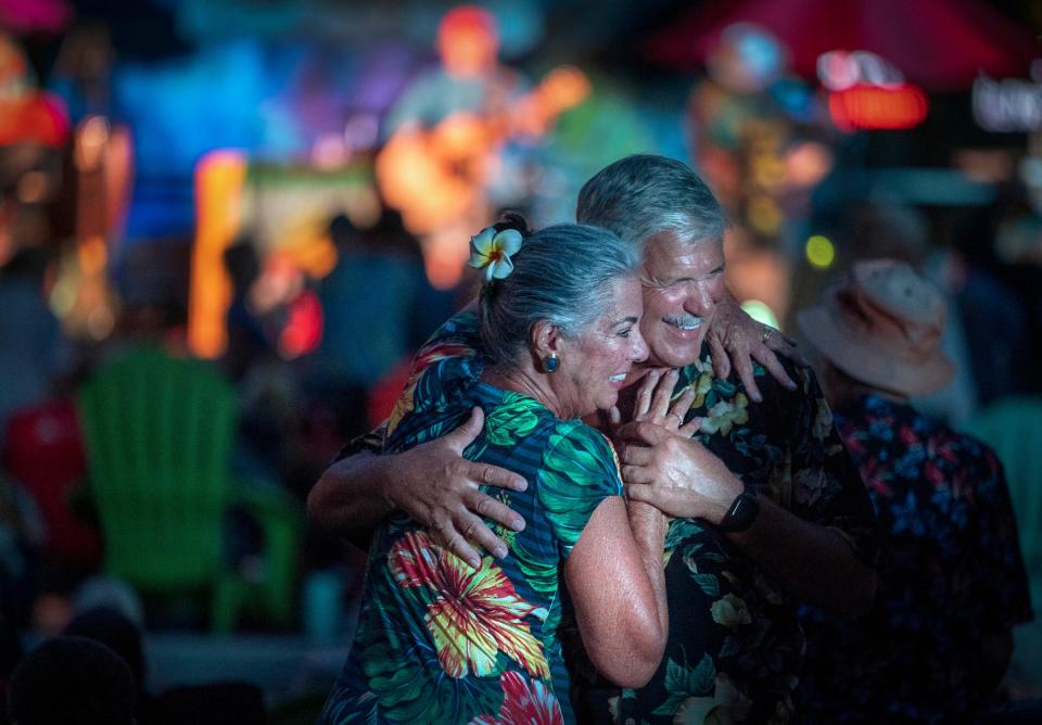A couple dances as the Jimmy Buffett tribute band The Caribbean Chillers performs during "Clematis by Night Celebrates Jimmy Buffett" in West Palm Beach on September 28, 2023.