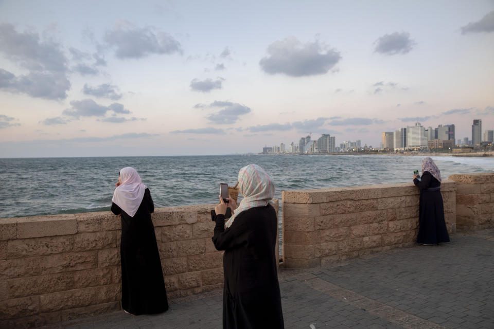 In this Monday, Sept. 23, 2019 photo, Israeli Arab women overlook the Mediterranean sea, in the mixed Arab Jewish city of Jaffa, near Tel Aviv, Israel. Electoral gains made by Arab parties in Israel, and their decision to endorse one of the two deadlocked candidates for prime minister, could give them new influence in parliament. But they also face a dilemma dating back to Israel's founding: How to participate in a system that they say relegates them to second-class citizens and oppresses their Palestinian brethren in Gaza and the occupied West Bank. (AP Photo/Oded Balilty)