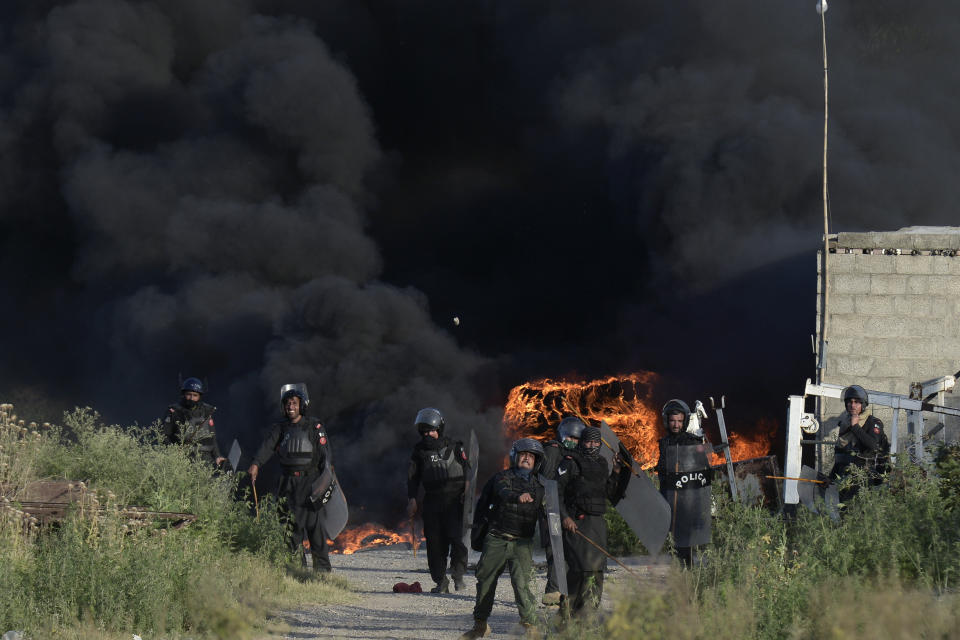 Police officers throw stones towards supporters of Pakistan's former Prime Minister Imran Khan during clashes, in Islamabad, Pakistan, Wednesday, May 10, 2023. Khan appeared in court Wednesday, a day after he was dragged from another court and arrested in Islamabad, and his supporters clashed with police across the country. A judge was asked to approve keeping the 70-year-old opposition leader in custody for up to 14 days. (AP Photo)