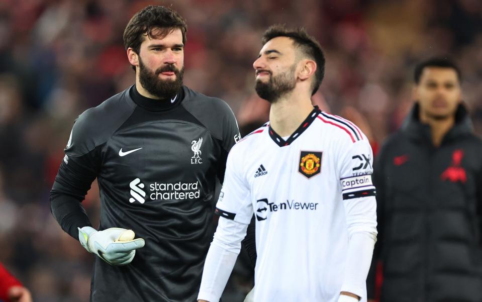 A dejected Bruno Fernandes of Manchester United with Alisson Becker of Liverpool after losing 7-0 during the Premier League match between Liverpool FC and Manchester United at Anfield on March 5, 2023 in Liverpool, United Kingdom