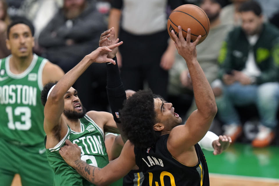 Golden State Warriors forward Anthony Lamb, right, drives toward the basket as Boston Celtics guards Derrick White, center, and Malcolm Brogdon (13) defend in the first half of an NBA basketball game, Thursday, Jan. 19, 2023, in Boston. (AP Photo/Steven Senne)