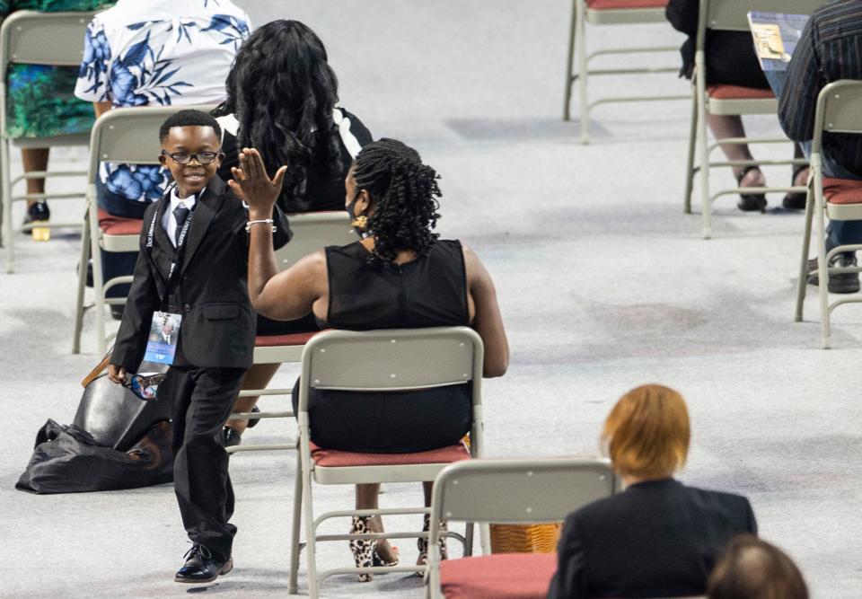 Jaxon Lewis Brewster gets a high five after speaking during the memorial services for his Great Uncle Congressman John Lewis at Trojan Arena in Troy, Ala., on Saturday, July 25, 2020.