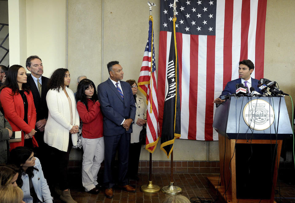 Fall River Mayor Jasiel Correia with family and supporters while he tells his side of the story about his indictment during a press conference Tuesday, Oct. 16, 2018, held at the Fall River Government Center in Fall River, Mass. (Dave Souza/The Herald News of Fall River via AP)