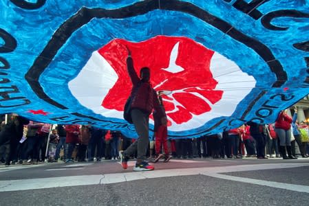 A child walks under a banner as hundreds of teachers and supporters march in Chicago