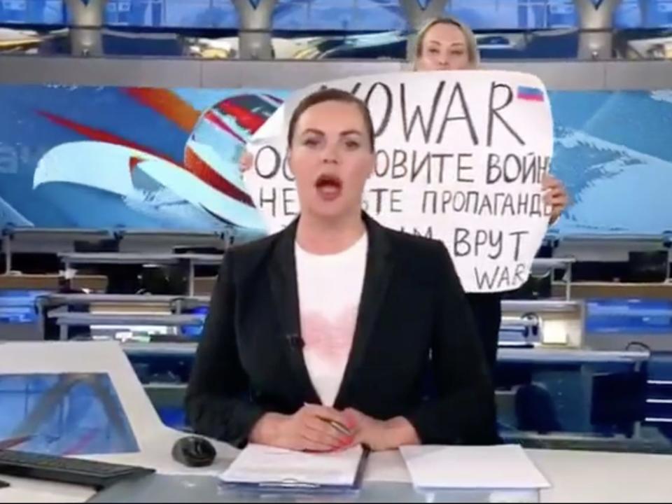 An anti-war protestor interrupts a Russian-state TV broadcast