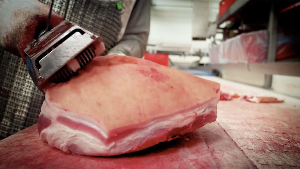 GRAPHIC: The pork skin is blowtorched before it is sliced off. Photo: Alina Kneepkens