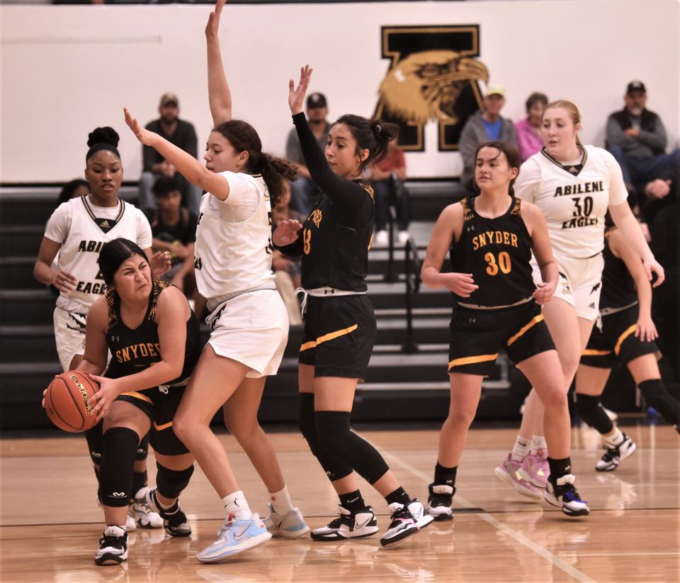 Snyder's Jayci Medrano looks to pass the ball around Abilene High's Taryn Moore as teammates Bethany Avalos (13) and Peyten Grope (30) look on.