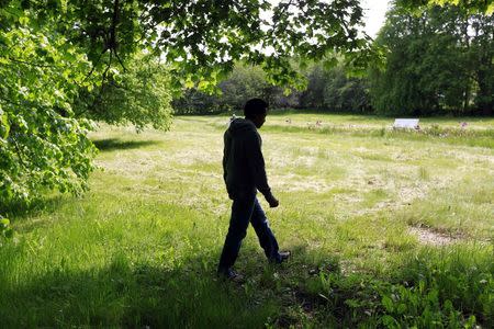 An asylum seeker walks outside the Bergby Gard hotel and conference centre, which houses asylum seekers, north of Stockholm June 6, 2014.REUTERS/Cathal McNaughton