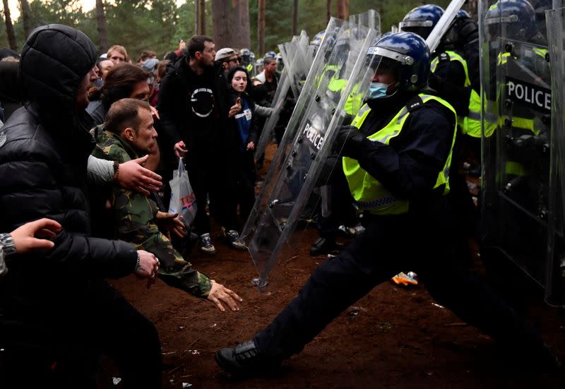 Revellers clash with riot police at the scene of a suspected illegal rave in Thetford Forest