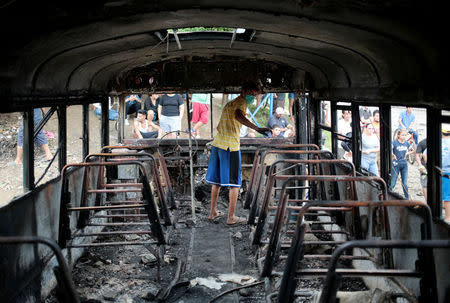 A protester stands inside a burned bus during a protest against Nicaragua's President Daniel Ortega's government in Tipitapa, Nicaragua June 14, 2018.REUTERS/Oswaldo Rivas