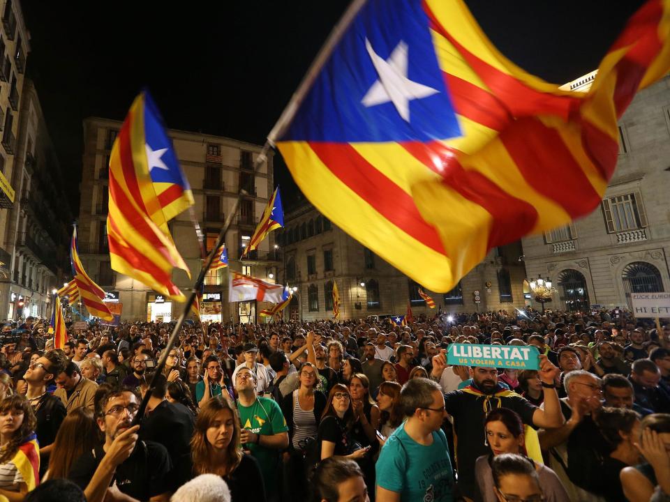 People wave Catalan independence flags in front of the Palau de la Generalitat de Catalunya, the building that houses the Catalonian presidency, following a demonstration for Catalan independence to demand the release of imprisoned Catalan leaders: Sean Gallup/Getty Images