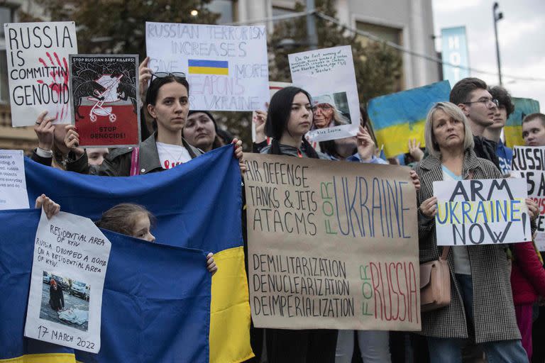 Los manifestantes sostienen banderas nacionales ucranianas, pancartas y carteles durante una manifestación para condenar los recientes ataques rusos en múltiples ciudades de Ucrania y exigir el apoyo a la defensa aérea eficiente de Ucrania, el 10 de octubre de 2022 en Praga, República Checa. 