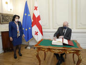 In this photo provided by the Georgian Presidential Press Office, European Council President Charles Michel signs the guest book as Georgia's President Salome Zurabishvili looks on in Tbilisi, Georgia, Monday, March 1, 2021 (Georgian Presidential Press Office via AP)