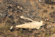 Rescue workers survey the site of a plane crash in the vilage of Saddha Batolni near Abbotabad, Pakistan December 8, 2016. . REUTERS/Faisal Mahmood