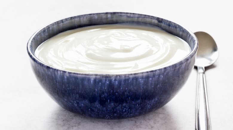 plain yogurt in blue bowl with spoon