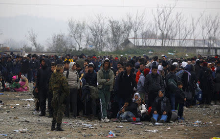 Migrants wait outside a registration camp after crossing the border between Greece and Macedonia, near Gevgelija, Macedonia November 21, 2015. REUTERS/Ognen Teofilovski