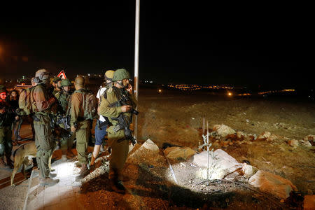 A Israeli soldier speaks on his mobile phone at the Israeli settlement Adam, after a Palestinian assailant stabbed three people and then was shot and killed, according to the Israeli military, in the occupied West Bank, July 26, 2018 REUTERS/Ronen Zvulun