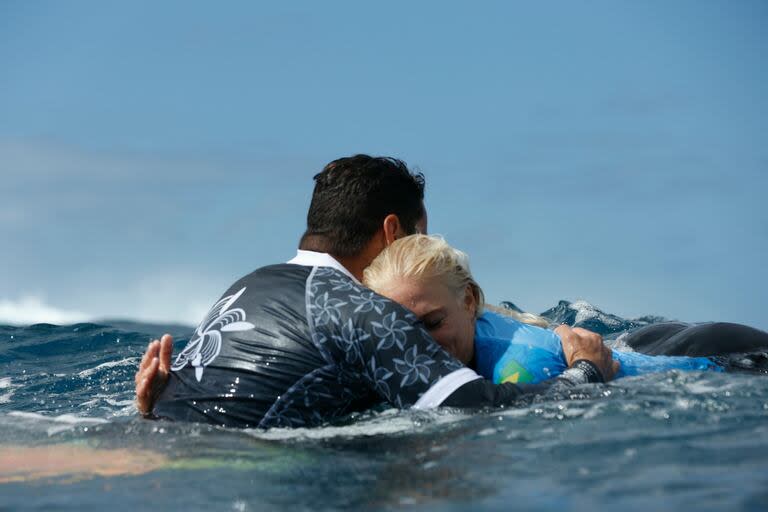 La brasileña Tatiana Weston-Webb se abraza con su entrenador después de competir en la ronda 3 de surf femenino