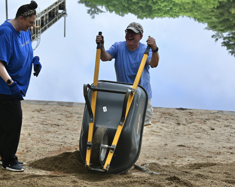 Unitil employees grab rakes, shovels in last-minute push to get Camp Tricklin’ Falls ready for new season.