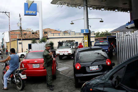 A Venezuelan soldier controls the traffic as motorists wait to pump gas into their cars at a gas station of the Venezuelan state-owned oil company PDVSA in San Antonio, Venezuela September 4, 2018. REUTERS/Carlos Eduardo Ramirez