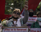 A relative of one of the missing 43 Ayotzinapa college students marches with a sign that has the image of her loved one and the phrase that reads in Spanish "They took him alive," in Mexico City, Monday, Sept. 26, 2022, on the day of the anniversary of the disappearance of the students in Iguala, Guerrero state. Three members of the military and a former federal attorney general were recently arrested in the case, and few now believe the government's initial claim that a local drug gang and allied local officials were wholly to blame for seizing and killing the students on July 26, 2014, most of which have never been found. (AP Photo/Eduardo Verdugo)