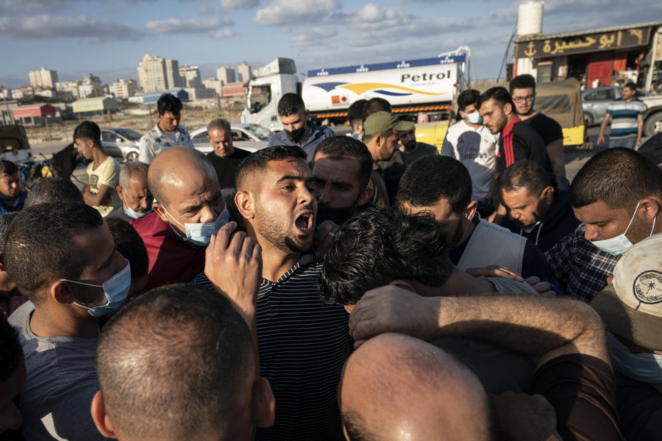 An auctioneer shouts numbers to recorders as the day's catch is sold to buyers after a limited number of fishing boats were allowed to return to the sea following a cease-fire reached after an 11-day war between Hamas and Israel, in Gaza City, Sunday, May 23, 2021. (AP Photo/John Minchillo)