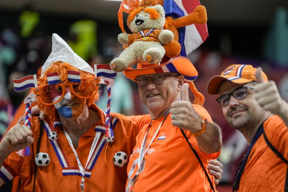 Netherlands supporters pose for a picture prior the start the World Cup group A football match between the Netherlands and Qatar, at the Al Bayt Stadium in Al Khor , Qatar, Tuesday, Nov. 29, 2022. (AP Photo/Moises Castillo)