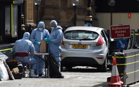 Police forensics officers near the car that crashed into a barrier outside Parliament - Credit: Eddie Mulholland for the Telegraph 