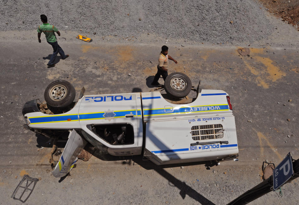 A South African Police truck that was overturned by farm workers after they went on a rampage in Wolseley, South Africa, Wednesday, Nov. 14, 2012. Violent protests by farm workers have erupted in South Africa after weeks of unrest in the country's mining industry. Television images showed protesters overturn a police truck and set fires in the streets Wednesday in a town in South Africa's Western Cape. The workers have been protesting their wages, saying they want a minimum wage of $17 a day. Currently, workers make about half that amount a day. (AP Photo)