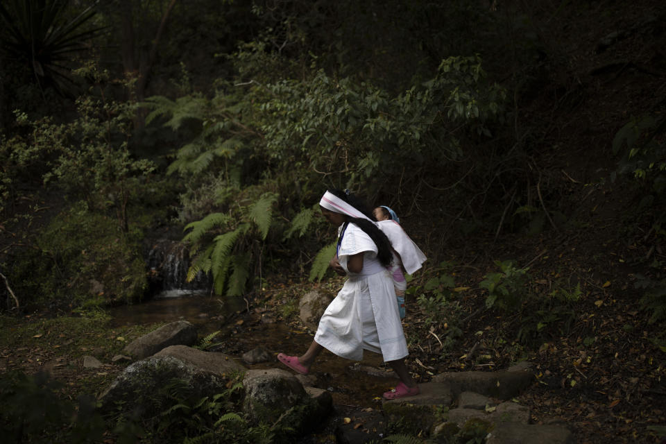 Una mujer indígena arhuaco carga a su bebé en Nabusimake en la Sierra Nevada de Santa Marta, Colombia, el martes 17 de enero de 2023. (AP Foto/Iván Valencia)