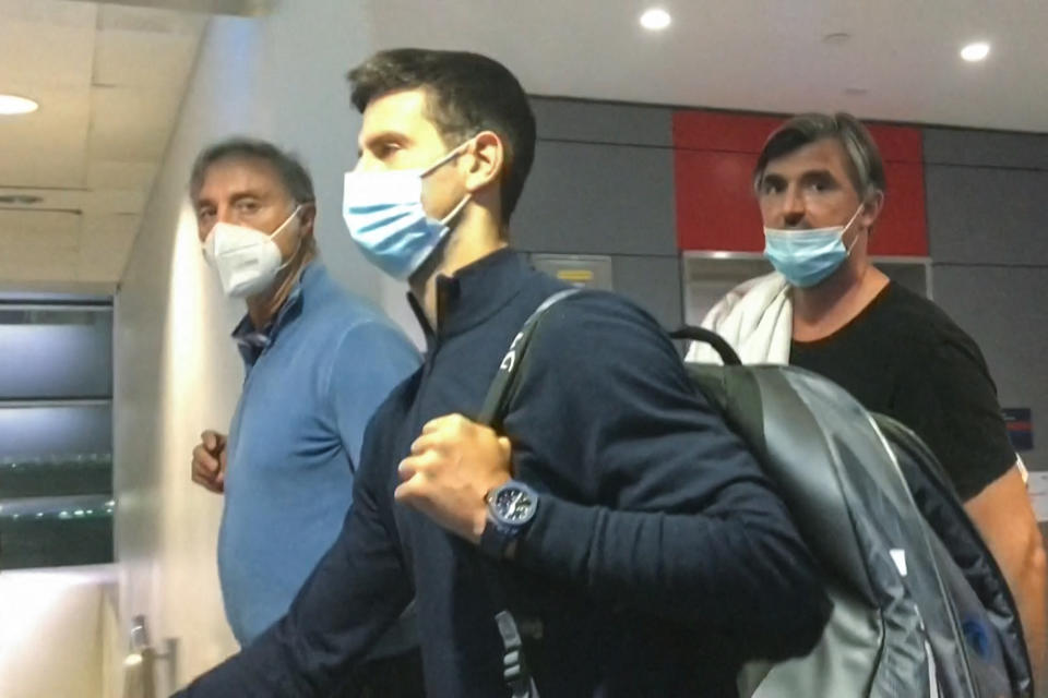 Novak Djokovic (pictured middle) walking in Dubai airport.