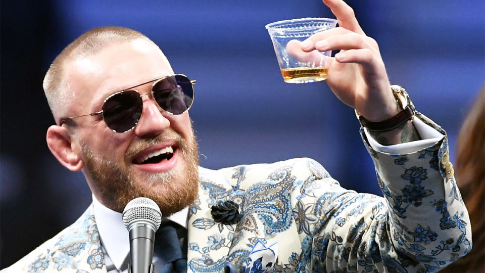 Conor McGregor (pictured) holding up a cup of Proper No. Twelve whiskey.