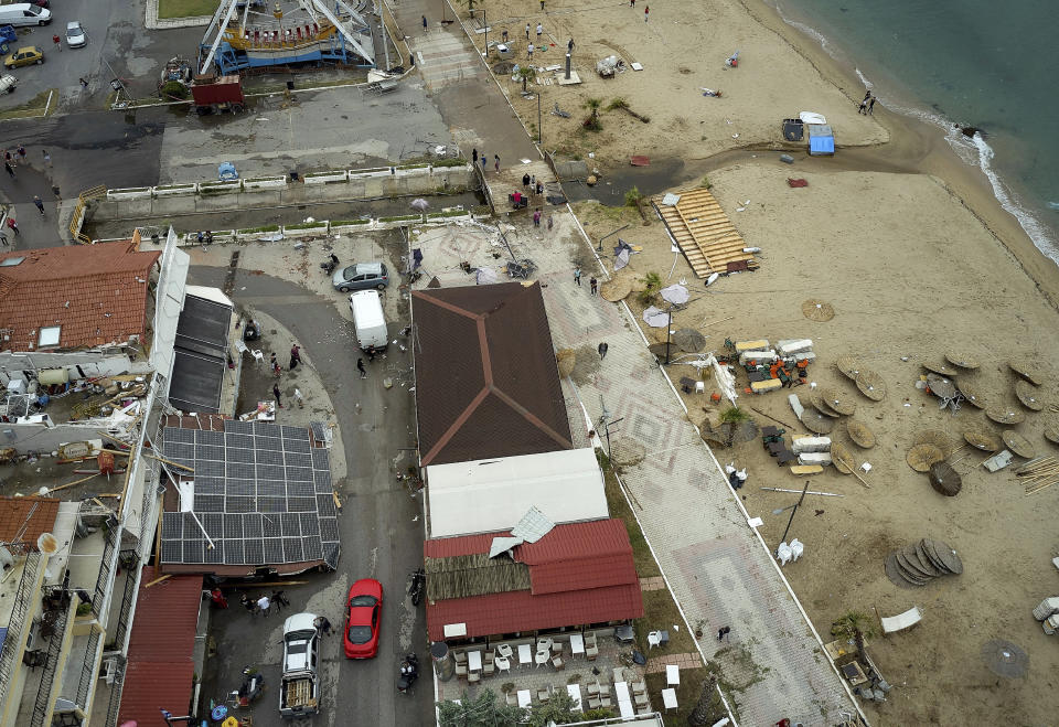 People search and clean after a storm at Sozopoli village in Halkidiki region, northern Greece, Thursday, July 11, 2019. A search and rescue operation is underway in northern Greece for a fisherman missing after a powerful storm left six people dead, including two children, and injured more than 100. (Vassilis Konstantopoulos/InTime News via AP)