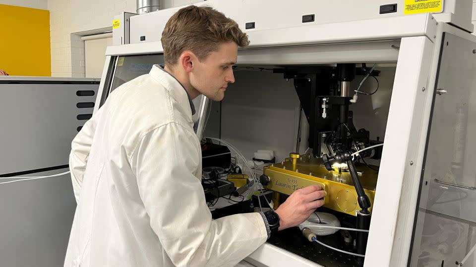 Curtin University PhD student Anthony Clarke examines samples taken from the Altar Stone in the laboratory. - Curtin University