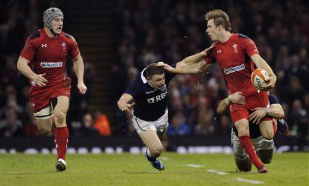 Wales' Liam Williams (R) passes to Jonathan Davies as he is tackled by Scotland's Duncan Weir during their Six Nations Championship rugby union match at the Millennium Stadium, Cardiff, Wales, March 15, 2014. REUTERS/Rebecca Naden