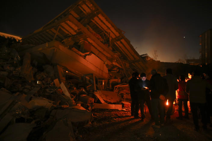 Rescue workers stand by a collapsed building in Adiyaman, southern Turkey, Thursday, Feb. 9, 2023. Thousands who lost their homes in a catastrophic earthquake huddled around campfires and clamored for food and water in the bitter cold, three days after the temblor and series of aftershocks hit Turkey and Syria. ( AP Photo/Emrah Gurel)