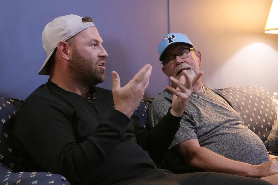 Jonathan Madden, left, signs for his father, Bob, during an interview before watching the Stanley Cup hockey final on their television, Monday, June 10, 2024 in Genoa Township, Mich. Bob Madden is deaf and he was enjoying the view with access to the commentary delivered in American Sign Language for the first time during a sporting event. The NHL became the first major sports league to offer play by play and analysis in ASL during a live broadcast. (AP Photo/Carlos Osorio)