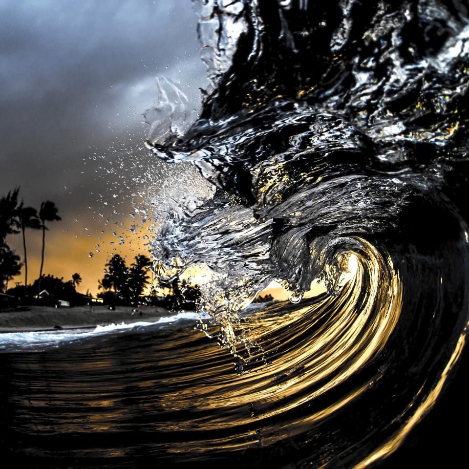 En esta fotografía sin fecha titulada "Obsidian", una ola iluminada por un flash de cámara mientas el sol se pone en la costa norte de Oahu cerca de Haleiwa, Hawái. La imagen aparece en el libro "The Art of Waves" del fotógrafo Clark Little. (Clark Little via AP)