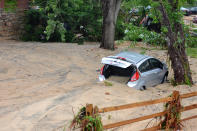 <p>A car that was swept into the riverbank rests just off Main Street in flood-ravaged Ellicott City, Md., Monday, May 28, 2018. Sunday’s destructive flooding left the former mill town heartbroken as it had bounded back from another destructive storm less than two years ago. (Photo: David McFadden/AP) </p>